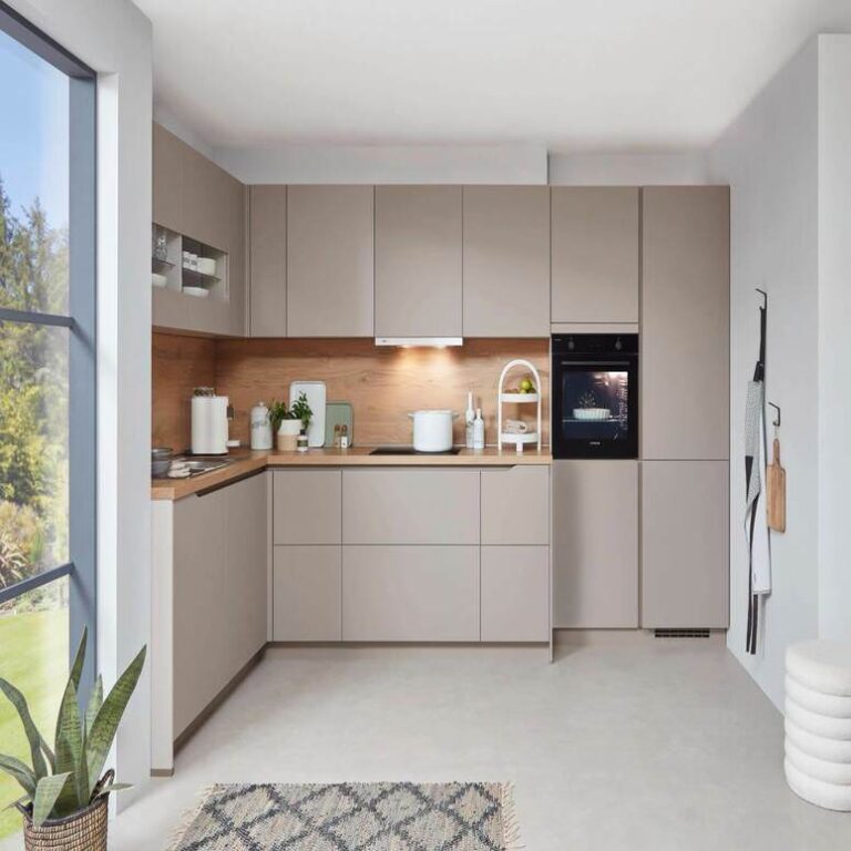 Musterküche in Kaschmir Musterküche in Kaschmir als L-Küche mit Holzrückwand und Backofen im Hochschrank – Küchenaufbau Ingolstadt